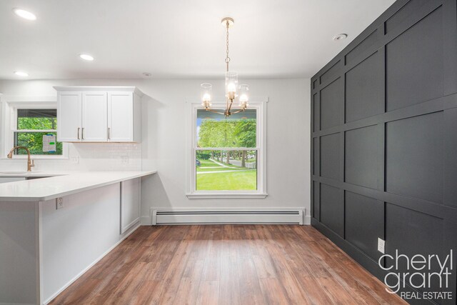 1757 Westlane Dr NE, Grand Rapids, MI 49505 - unfurnished dining area featuring baseboard heating, a chandelier, wood finished floors, and recessed lighting