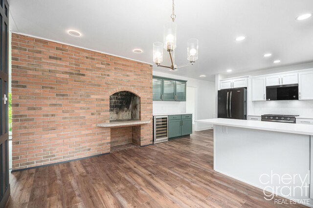 1757 Westlane Dr NE, Grand Rapids, MI 49505 - kitchen with freestanding refrigerator, black microwave, wine cooler, light countertops, and brick wall