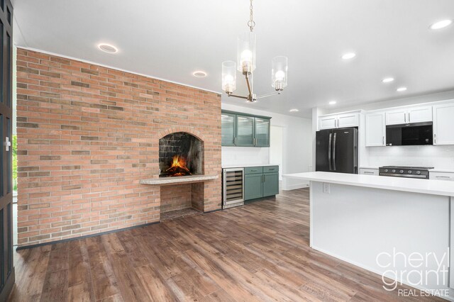 1757 Westlane Dr NE, Grand Rapids, MI 49505 - kitchen with freestanding refrigerator, beverage cooler, black microwave, light countertops, and brick wall