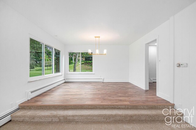 1757 Westlane Dr NE, Grand Rapids, MI 49505 - spare room with a baseboard radiator, a chandelier, baseboard heating, and wood finished floors