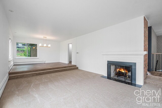 1757 Westlane Dr NE, Grand Rapids, MI 49505 - unfurnished living room with a baseboard heating unit, carpet floors, a chandelier, and a fireplace with flush hearth