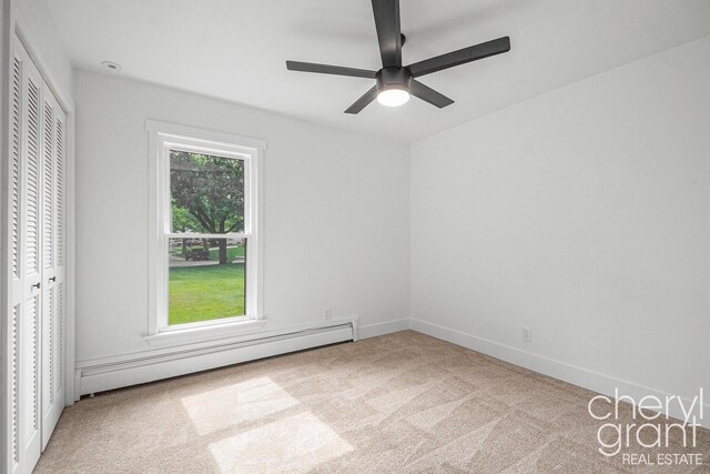 1757 Westlane Dr NE, Grand Rapids, MI 49505 - unfurnished bedroom featuring a baseboard heating unit, carpet flooring, ceiling fan, and a closet