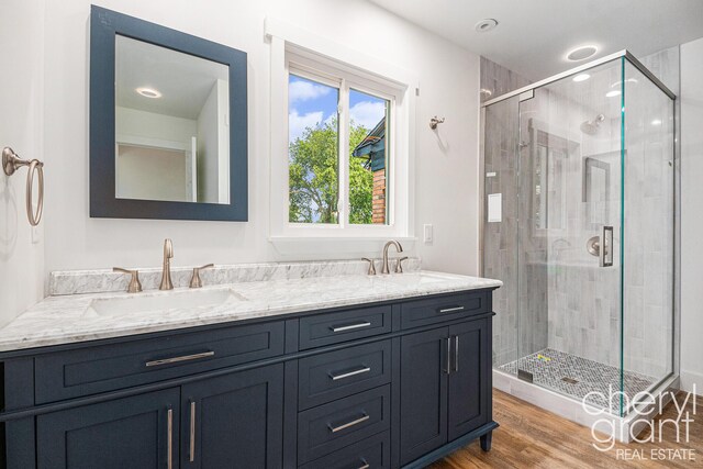 1757 Westlane Dr NE, Grand Rapids, MI 49505 - bathroom featuring a shower stall, double vanity, and wood finished floors
