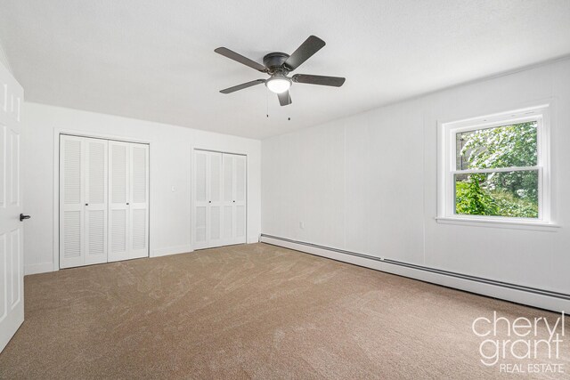 1757 Westlane Dr NE, Grand Rapids, MI 49505 - unfurnished bedroom featuring a baseboard radiator, two closets, carpet, and ceiling fan