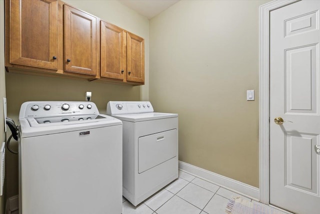 3667 Bay Harbor Dr, Brighton, MI 48114 - laundry room featuring washing machine and dryer, cabinet space, and light tile patterned floors