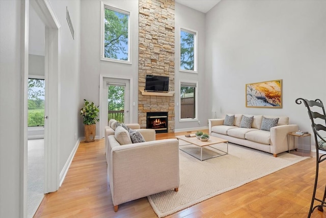 3667 Bay Harbor Dr, Brighton, MI 48114 - living area with a high ceiling, a fireplace, and light wood-type flooring