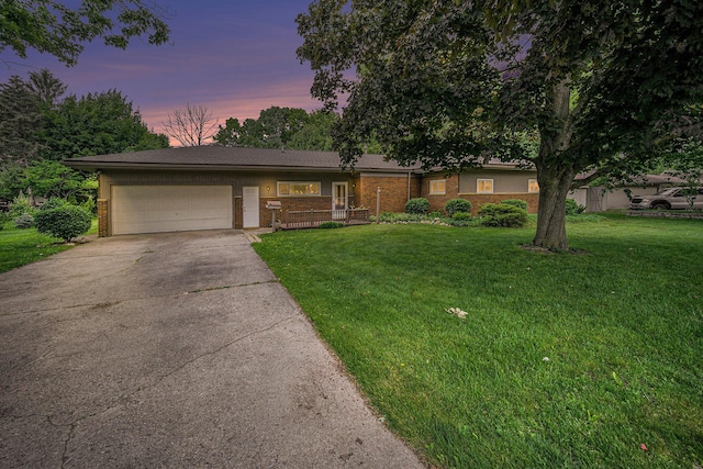 55 E Lewis Ave, Milan, MI 48160 - view of front of house with concrete driveway, an attached garage, a yard, and brick siding