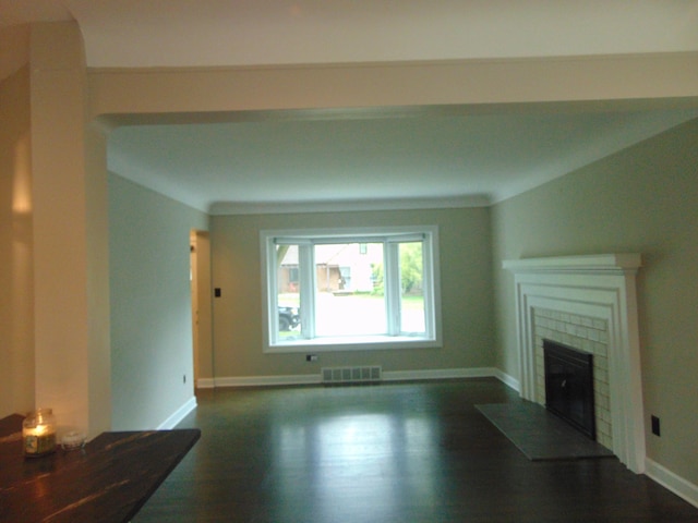 10114 Lincoln Dr, Huntington Woods, MI 48070 - unfurnished living room featuring baseboards, a tiled fireplace, and dark wood-style floors
