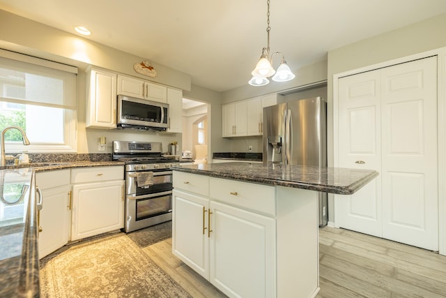 45801 Henley Dr, Canton, MI 48187 - kitchen with stainless steel appliances, a kitchen island, white cabinetry, light wood-style flooring, and recessed lighting