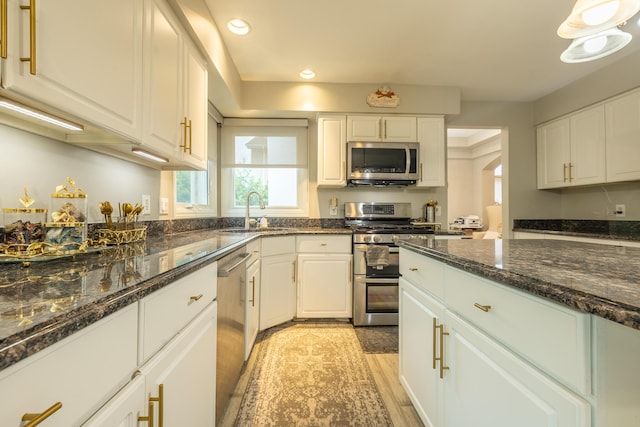 45801 Henley Dr, Canton, MI 48187 - kitchen with stainless steel appliances, white cabinetry, recessed lighting, light wood finished floors, and dark stone countertops