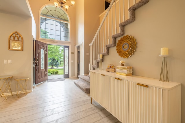 45801 Henley Dr, Canton, MI 48187 - foyer featuring stairs, a chandelier, a towering ceiling, and light wood-style floors
