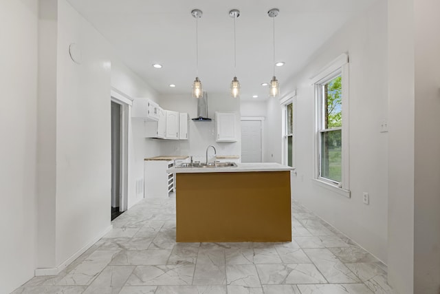 3008 Lothrop St, Detroit, MI 48206 - kitchen featuring wall chimney exhaust hood, white cabinets, light marble finish floors, an island with sink, and recessed lighting