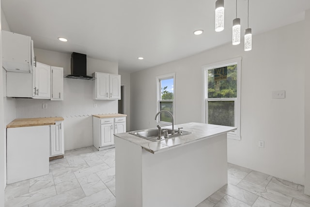 3008 Lothrop St, Detroit, MI 48206 - kitchen featuring wall chimney range hood, light marble finish flooring, recessed lighting, white cabinets, and an island with sink