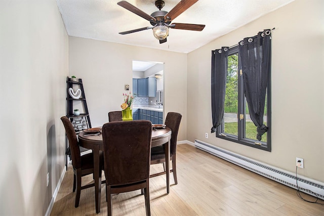 6236 Arbutus, Idlewild, MI 49642 - dining area featuring a baseboard radiator, light wood-type flooring, and ceiling fan