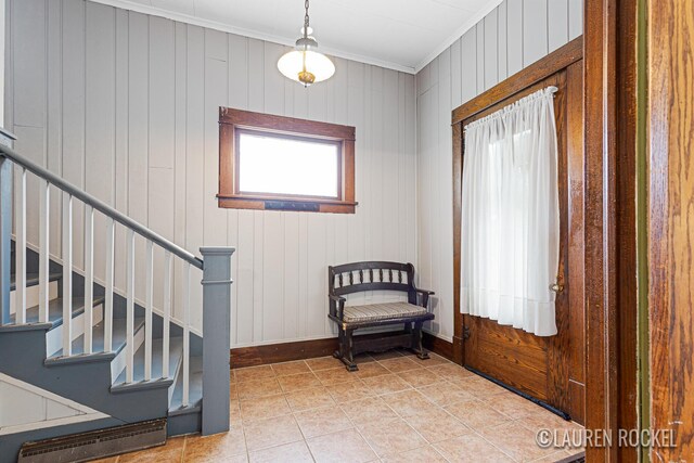 409 Rust Ave, Big Rapids, MI 49307 - foyer featuring crown molding, stairs, light tile patterned floors, and wood walls