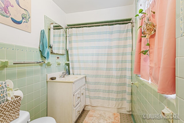 409 Rust Ave, Big Rapids, MI 49307 - full bath with tile walls, vanity, a shower with curtain, wainscoting, and tile patterned floors