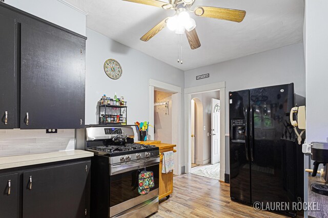 409 Rust Ave, Big Rapids, MI 49307 - kitchen with gas stove, black refrigerator with ice dispenser, dark cabinetry, ceiling fan, and light countertops