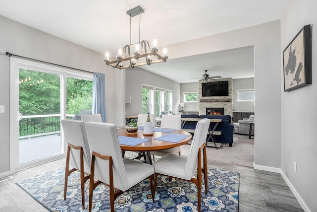 3935 Riley Rdg, Portage, MI 49024 - dining room with a large fireplace, a chandelier, a ceiling fan, and wood finished floors