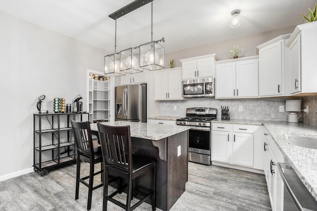 3935 Riley Rdg, Portage, MI 49024 - kitchen featuring appliances with stainless steel finishes, a kitchen island, light wood-type flooring, and backsplash