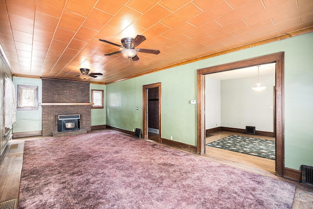 106 E Mechanic St, Yale, MI 48097 - unfurnished living room with crown molding, plenty of natural light, ceiling fan, wood finished floors, and a fireplace