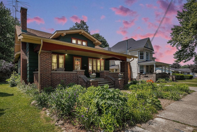 106 E Mechanic St, Yale, MI 48097 - view of front of home featuring a porch, a chimney, and brick siding