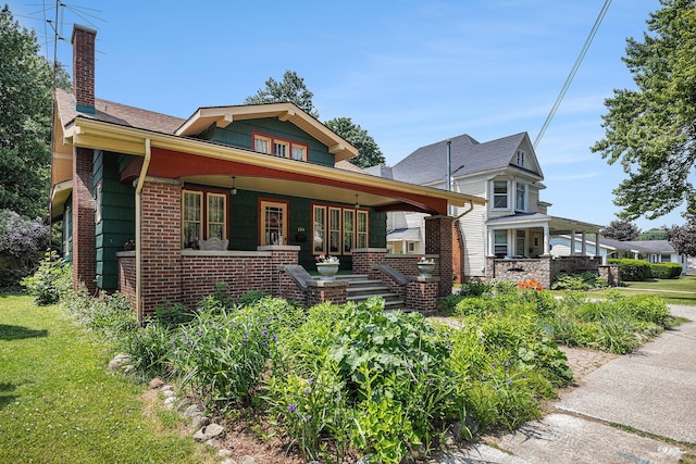 106 E Mechanic St, Yale, MI 48097 - bungalow-style home with covered porch, a chimney, and brick siding