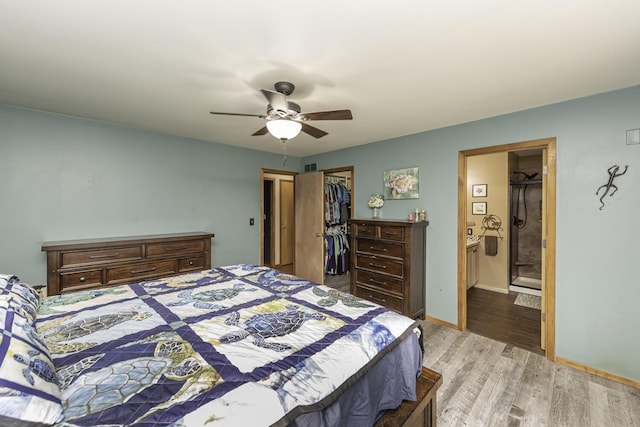 7715 Marquis Dr, Dexter, MI 48130 - bedroom featuring light wood-style flooring, a spacious closet, ceiling fan, and connected bathroom