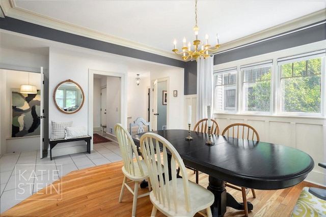 859 Orchard Ave SE, East Grand Rapids, MI 49506 - dining area with a chandelier, ornamental molding, healthy amount of natural light, light wood-style flooring, and a decorative wall