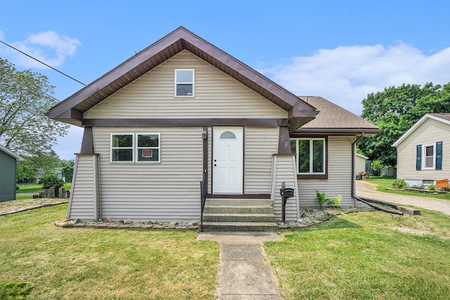 59 Dunning Ave, Battle Creek, MI 49037 - bungalow-style home with a front yard, entry steps, and a shingled roof