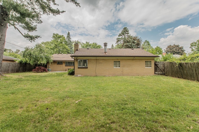 25255 Orchard Grove St, Southfield, MI 48033 - rear view of house with a fenced backyard, a chimney, and brick siding
