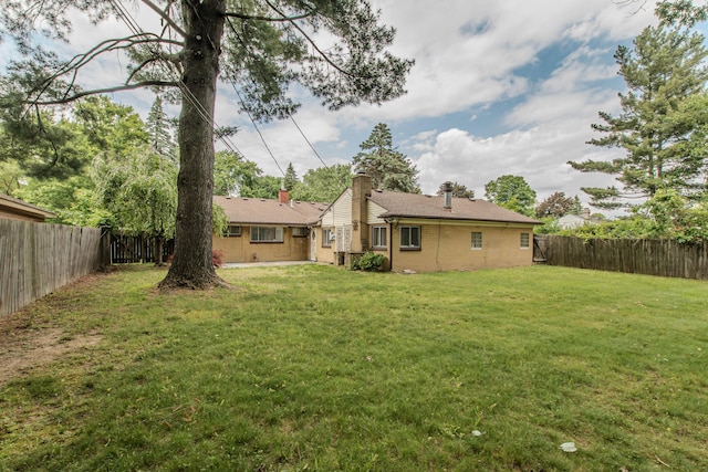 25255 Orchard Grove St, Southfield, MI 48033 - rear view of property featuring brick siding, a fenced backyard, and a chimney