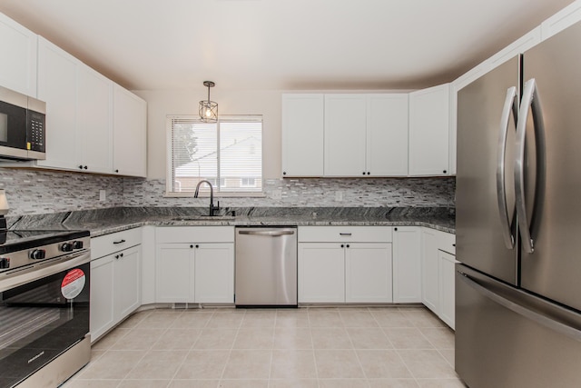 25255 Orchard Grove St, Southfield, MI 48033 - kitchen featuring appliances with stainless steel finishes, decorative backsplash, white cabinetry, light tile patterned floors, and dark stone counters