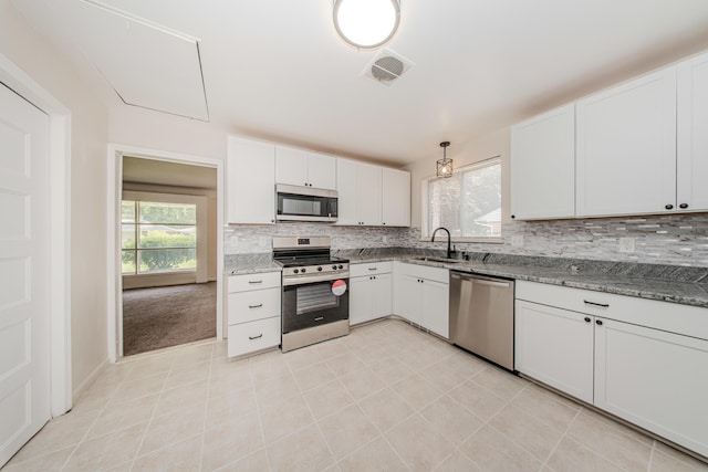25255 Orchard Grove St, Southfield, MI 48033 - kitchen with stainless steel appliances, decorative backsplash, light tile patterned flooring, white cabinetry, and light stone countertops