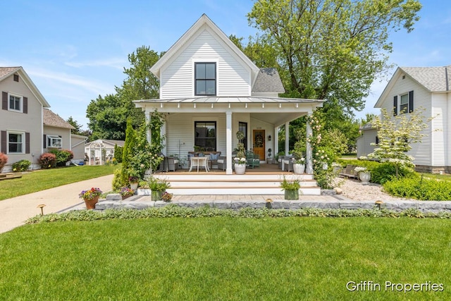 339 W Main Ave, Zeeland, MI 49464 - back of house featuring covered porch, a standing seam roof, a lawn, and a metal roof