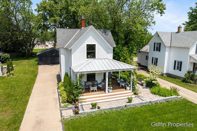 339 W Main Ave, Zeeland, MI 49464 - rear view of house with a yard, an outdoor hangout area, a standing seam roof, roof with shingles, and a chimney