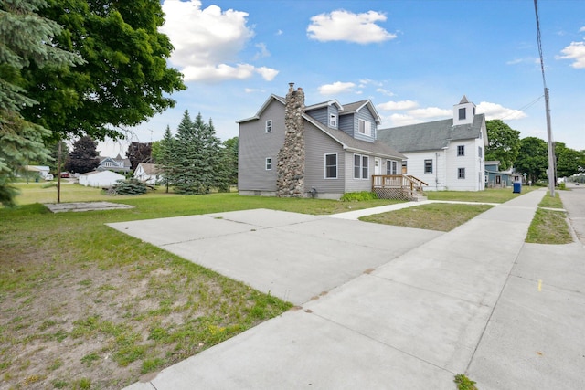 313 E Main St, Marion, MI 49665 - view of side of home featuring a lawn and a chimney
