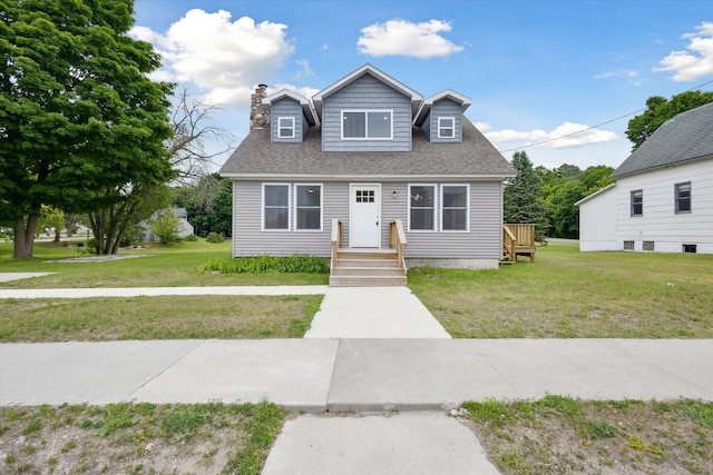 313 E Main St, Marion, MI 49665 - cape cod home with a front lawn, a chimney, and roof with shingles