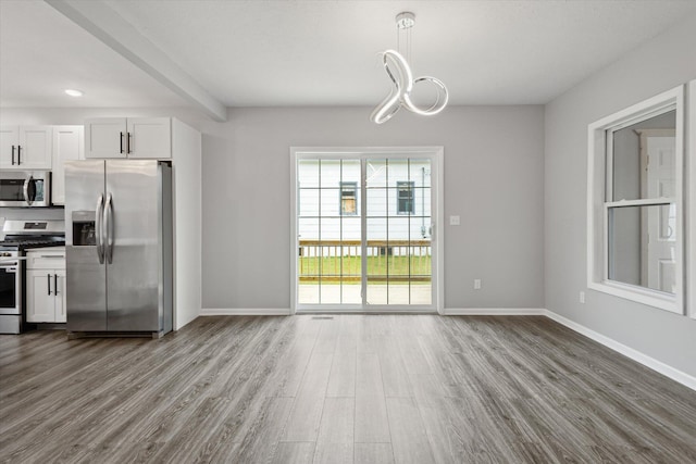 313 E Main St, Marion, MI 49665 - unfurnished dining area featuring dark wood-type flooring and a chandelier