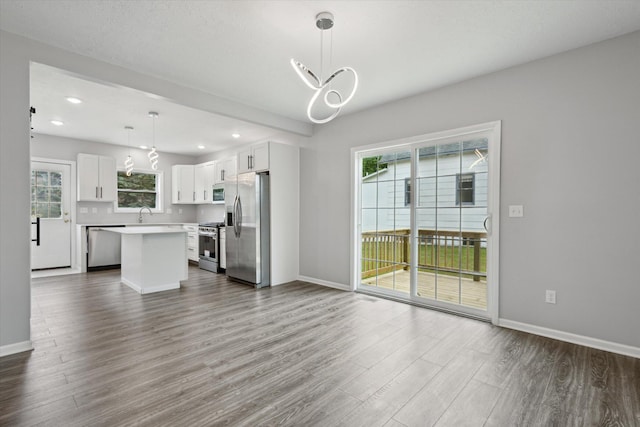 313 E Main St, Marion, MI 49665 - unfurnished living room with dark wood-style flooring, recessed lighting, plenty of natural light, and a chandelier