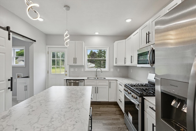 313 E Main St, Marion, MI 49665 - kitchen with appliances with stainless steel finishes, a barn door, plenty of natural light, white cabinets, and recessed lighting