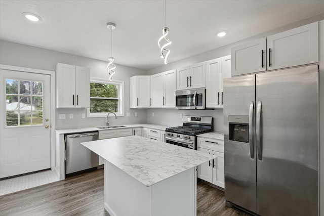 313 E Main St, Marion, MI 49665 - kitchen featuring stainless steel appliances, dark wood-style floors, light countertops, a center island, and white cabinets