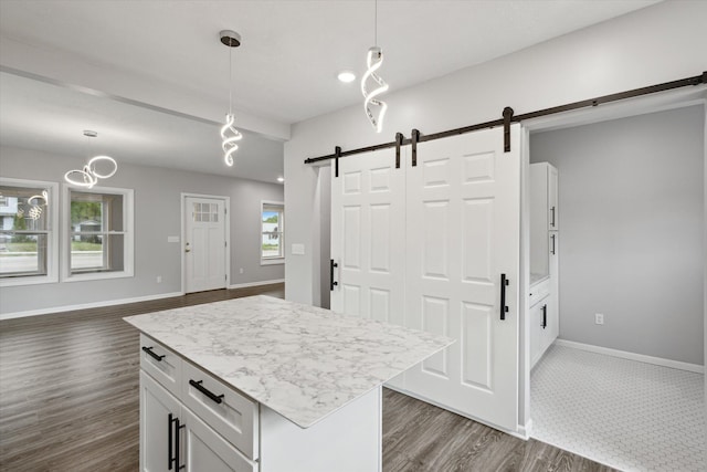 313 E Main St, Marion, MI 49665 - kitchen featuring a barn door, dark wood finished floors, decorative light fixtures, white cabinets, and a center island