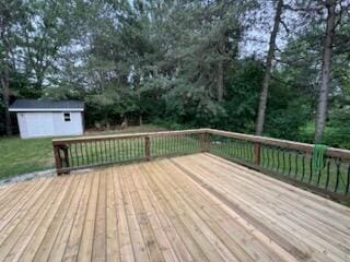 5689 Rothbury Ct, Ypsilanti, MI 48197 - wooden deck with a storage unit and view of wooded area