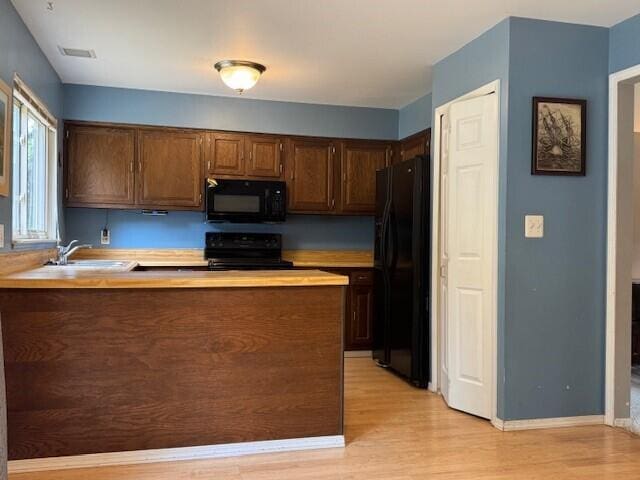 5689 Rothbury Ct, Ypsilanti, MI 48197 - kitchen with black appliances, light wood-type flooring, a peninsula, and light countertops