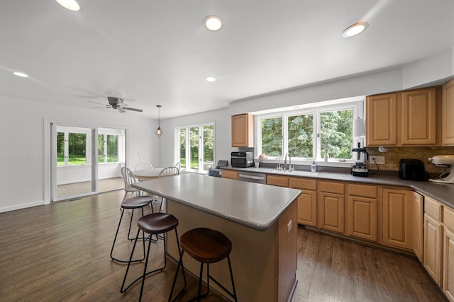 7624 Quail Ridge Dr, Dexter, MI 48130 - kitchen featuring a breakfast bar, dishwasher, a center island, a ceiling fan, and dark wood-style floors