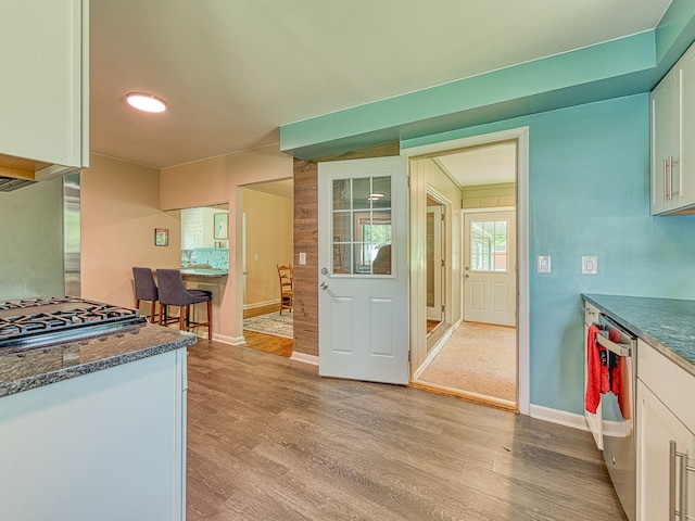 219 Park St, Tecumseh, MI 49286 - kitchen with light wood-style floors, white cabinets, gas cooktop, and stainless steel dishwasher