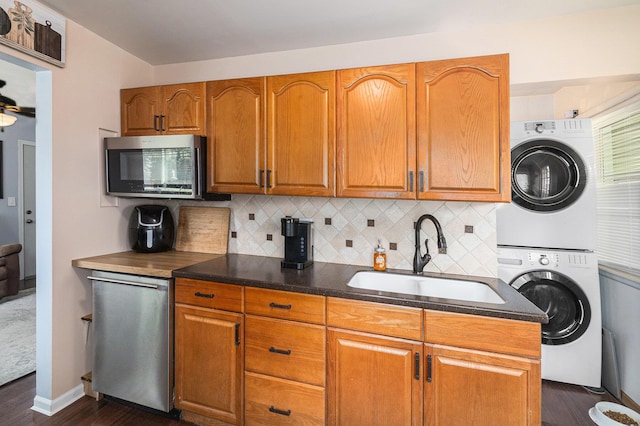 1198 Hawthorne Ave, Ypsilanti, MI 48198 - kitchen featuring stacked washer / drying machine, stainless steel microwave, dark wood-style floors, and decorative backsplash