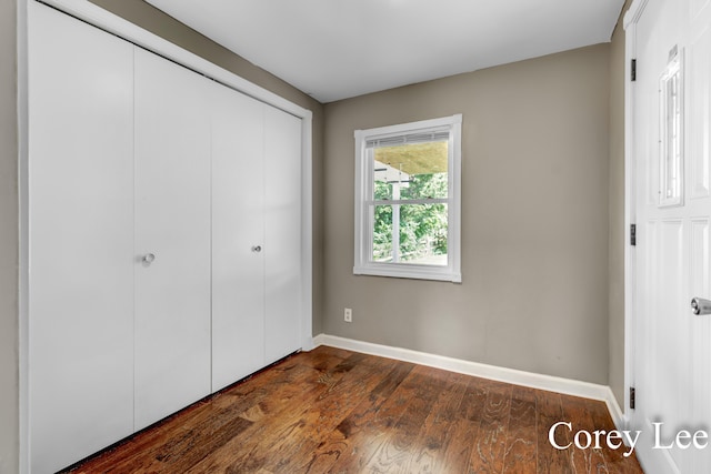413 W Riverside Dr, Ionia, MI 48846 - unfurnished bedroom featuring a closet and dark wood-style floors