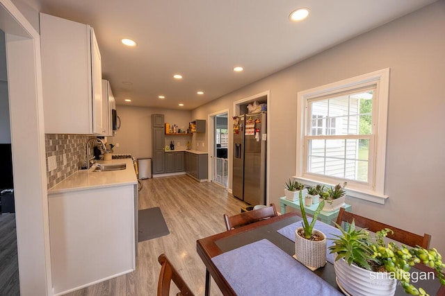 5161 Grand River Dr NE, Grand Rapids, MI 49525 - kitchen featuring stainless steel refrigerator with ice dispenser, light countertops, light wood finished floors, recessed lighting, and tasteful backsplash