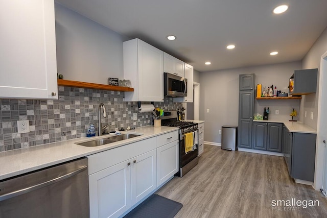 5161 Grand River Dr NE, Grand Rapids, MI 49525 - kitchen featuring appliances with stainless steel finishes, open shelves, light wood-type flooring, light countertops, and recessed lighting